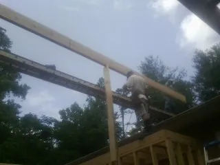 Carpenter setting a ridge beam over a new addition frame — Ice Dam Removal by Roofing Brothers in Lone Jack