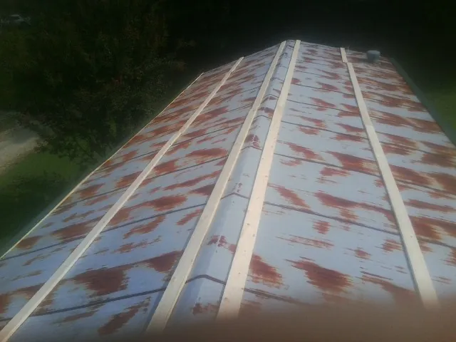 Rusted metal roof panels with new wood purlins before replacement — Storm Damage Roof Repair in Lone Jack by Roofing Brothers